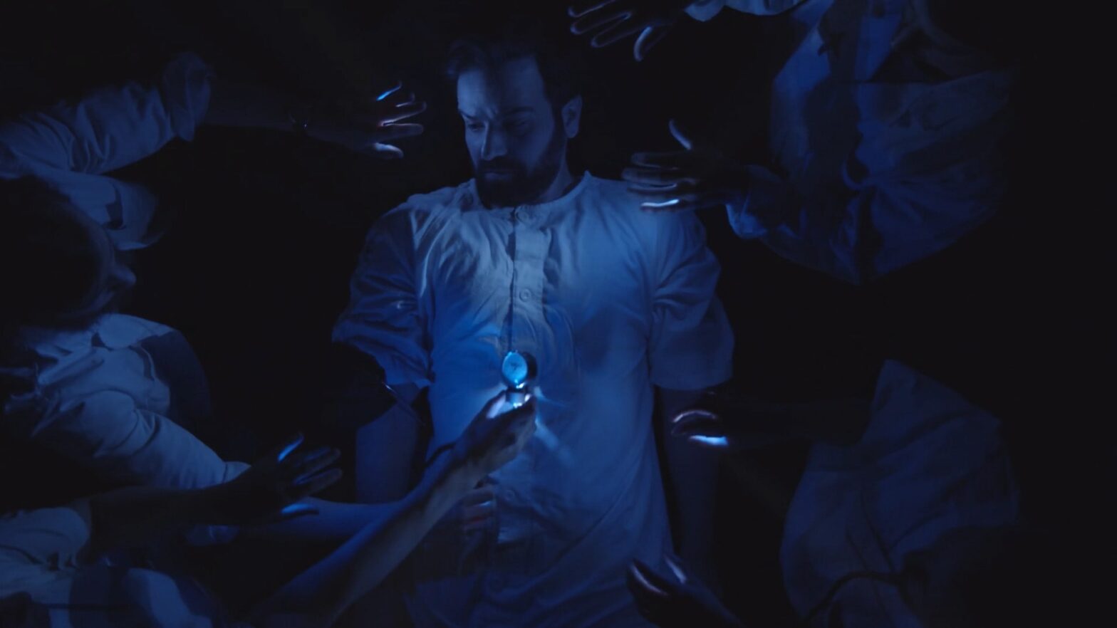 Man in hospital clothes in a dark environment with blue lights